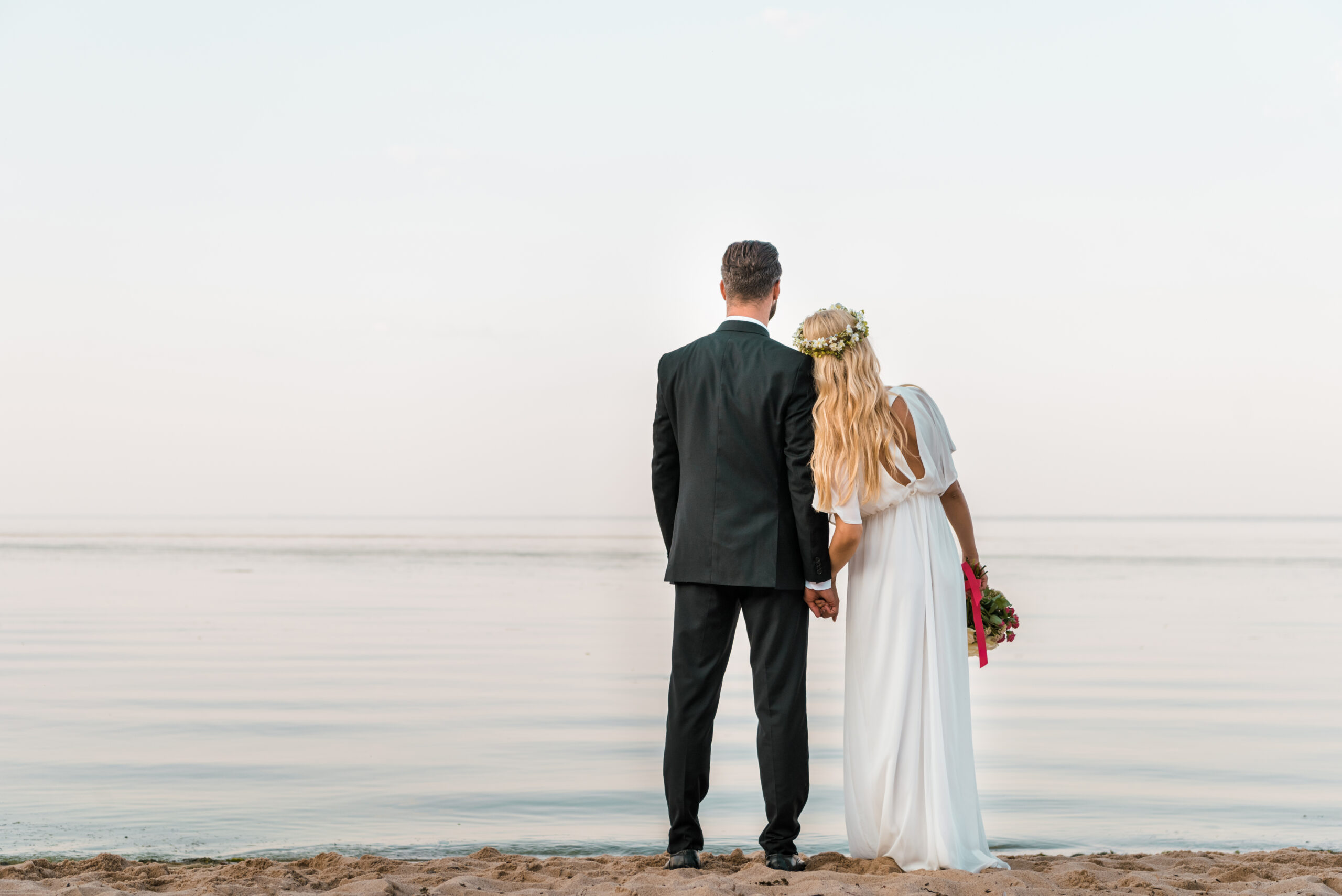 Hochzeitspaar steht am Nordseestrand